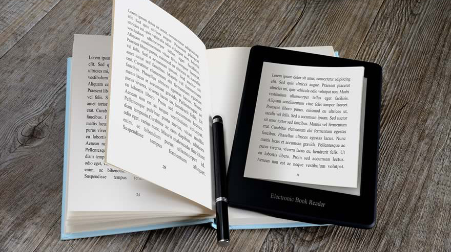 An electronic book reader and a pen placed over an open book on a table.